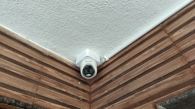 CCTV camera mounted near a wood-panelled indoor corner